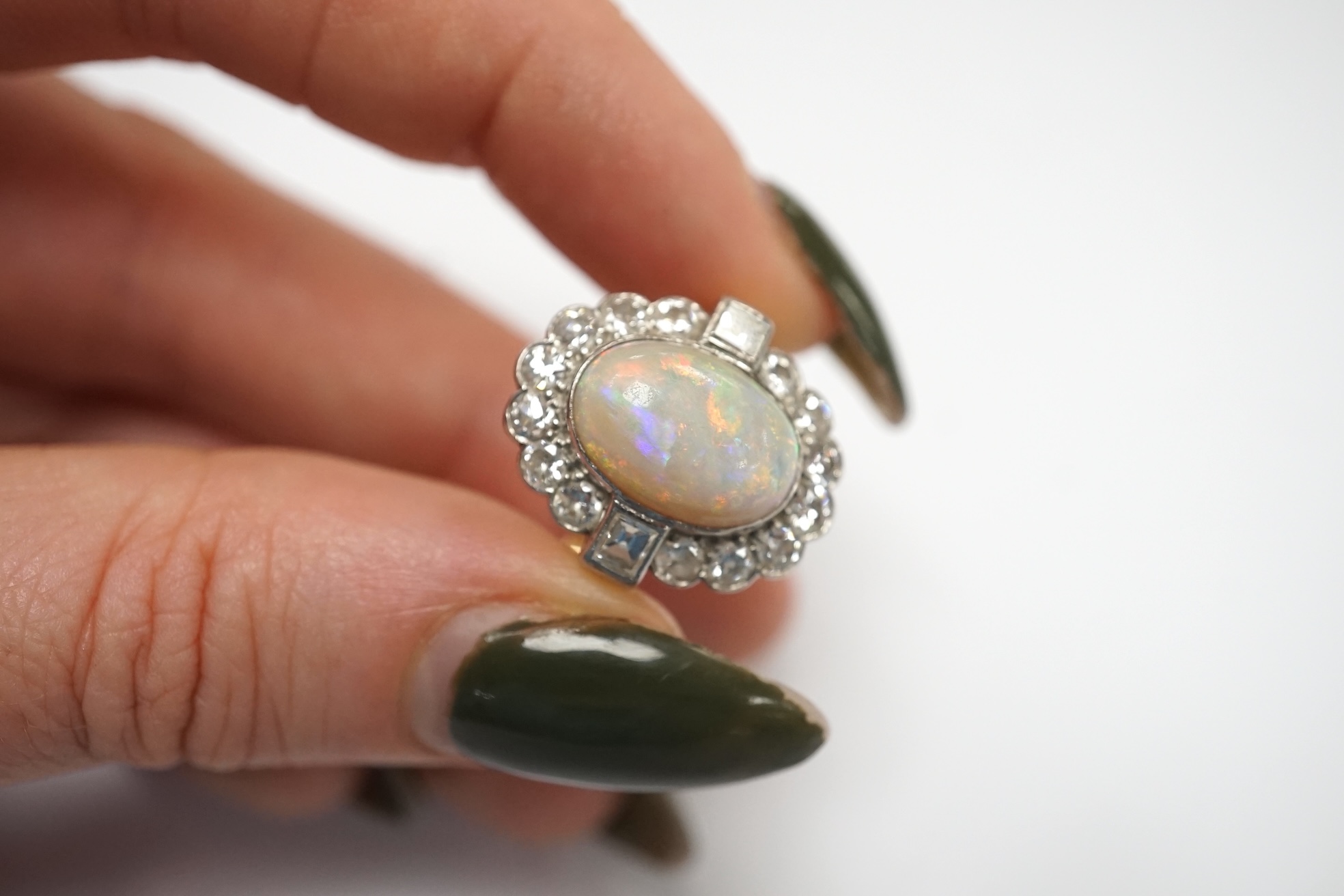 A mid 20th century 18ct, white opal, square and round cut diamond set oval cluster ring, size O, gross weight 3.3 grams. Condition - fair